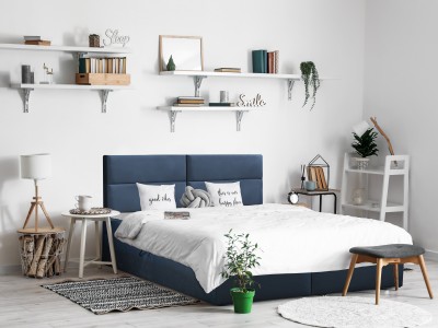 Interior of modern bedroom with tables and houseplants